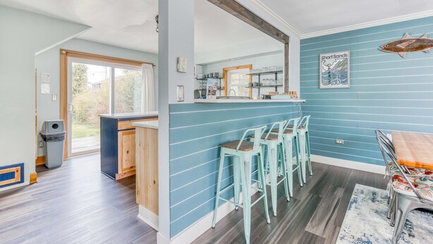 Eine Küche mit blauer Wand, Holzschränken und einer Bar mit Sitzhocker.
