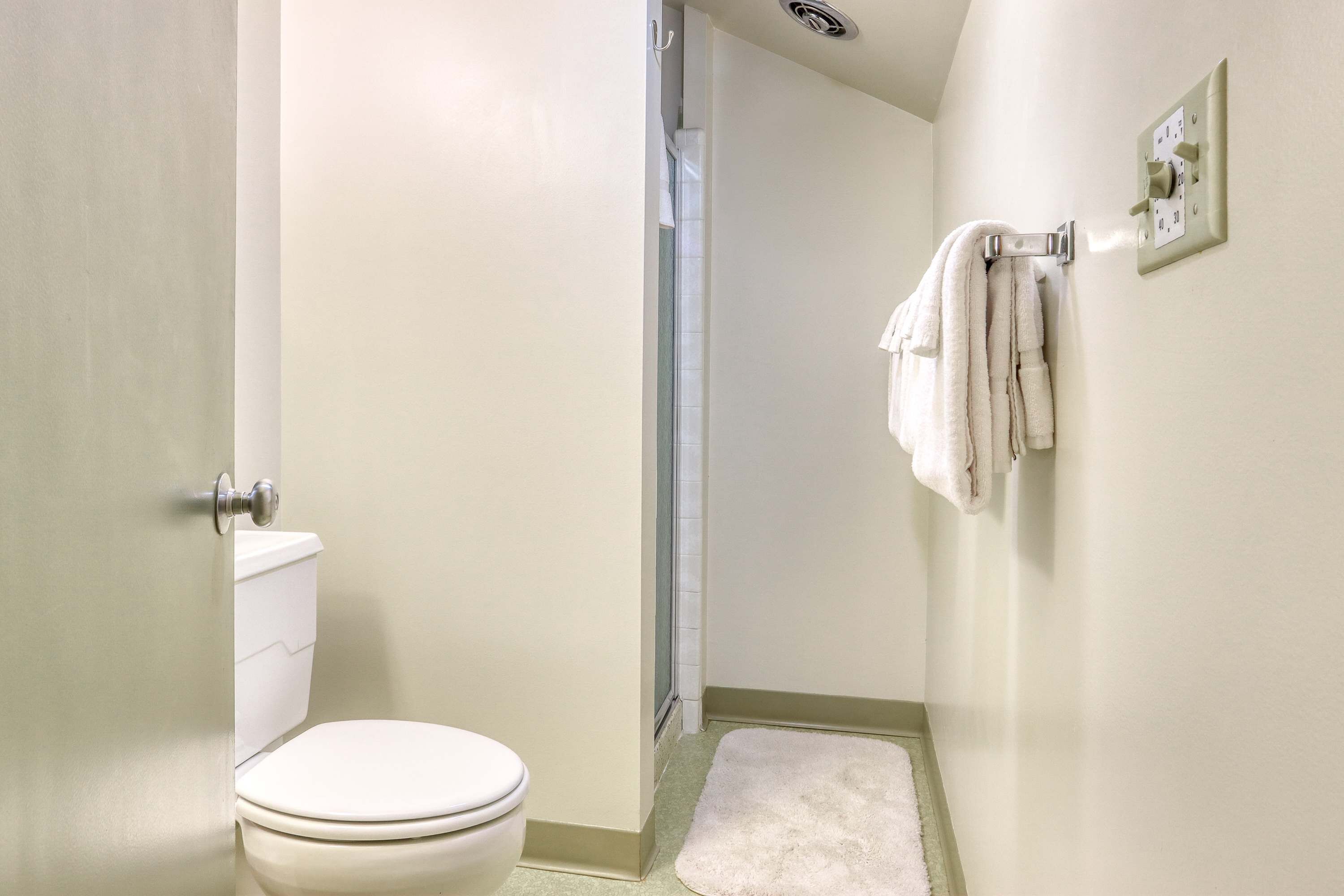 Une salle de bain équipée de toilettes, d’une douche et d’un porte-serviettes.