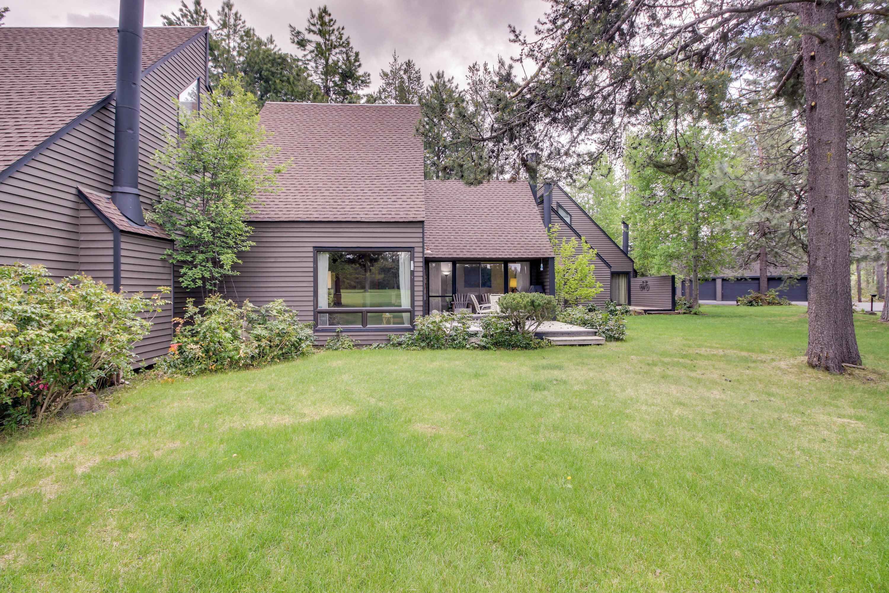 A modern house with a sloped roof, a chimney, and a well-maintained lawn.
