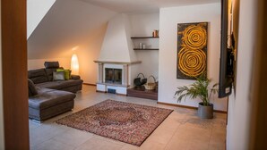 Una sala de estar moderna con chimenea, un sofá, una alfombra y una obra de arte en la pared.