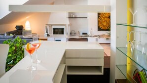Una sala de estar moderna con un sofá blanco, una mesa de centro de vidrio y una copa de martini con una rodaja de limón.
