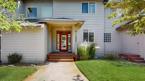 A two-story house with a front porch, a red door, and a number '1020' on the wall.
