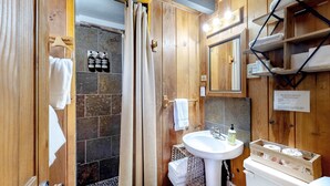 A wooden bathroom with a shower, a sink, and a mirror. - Cozy, comfortable cottage in Government Camp (Government Camp)