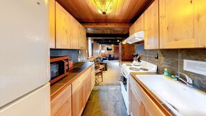 A modern kitchen with wooden cabinets, a stove, and a microwave. - Cozy, comfortable cottage in Government Camp (Government Camp)