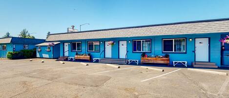 A blue building with a parking lot in front.