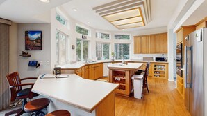 Een moderne keuken met houten kastjes, een groot eiland en een inbouwoven.