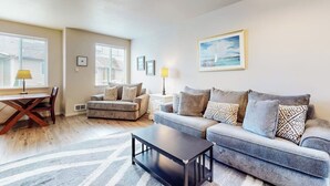 A living room with a sofa, coffee table, and a dining table with chairs. - Dog-friendly condo with river views, private W&D, full kitchen, & great location (Florence)