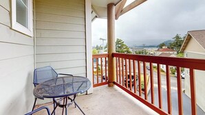 A balcony with a table and chairs, a wooden railing, and a view of a residential area. - Dog-friendly condo with river views, private W&D, full kitchen, & great location (Florence)