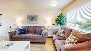 A living room with two sofas, a coffee table, and a decorative wall piece.