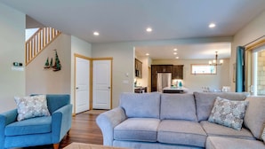 A living room with a sofa, a coffee table, and a blue armchair. - Kid-friendly house with fireplace, entertainment, and nearby beach access (Manzanita)