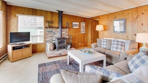 Ein gemütliches Wohnzimmer mit Kamin, Fernseher und Sofa.