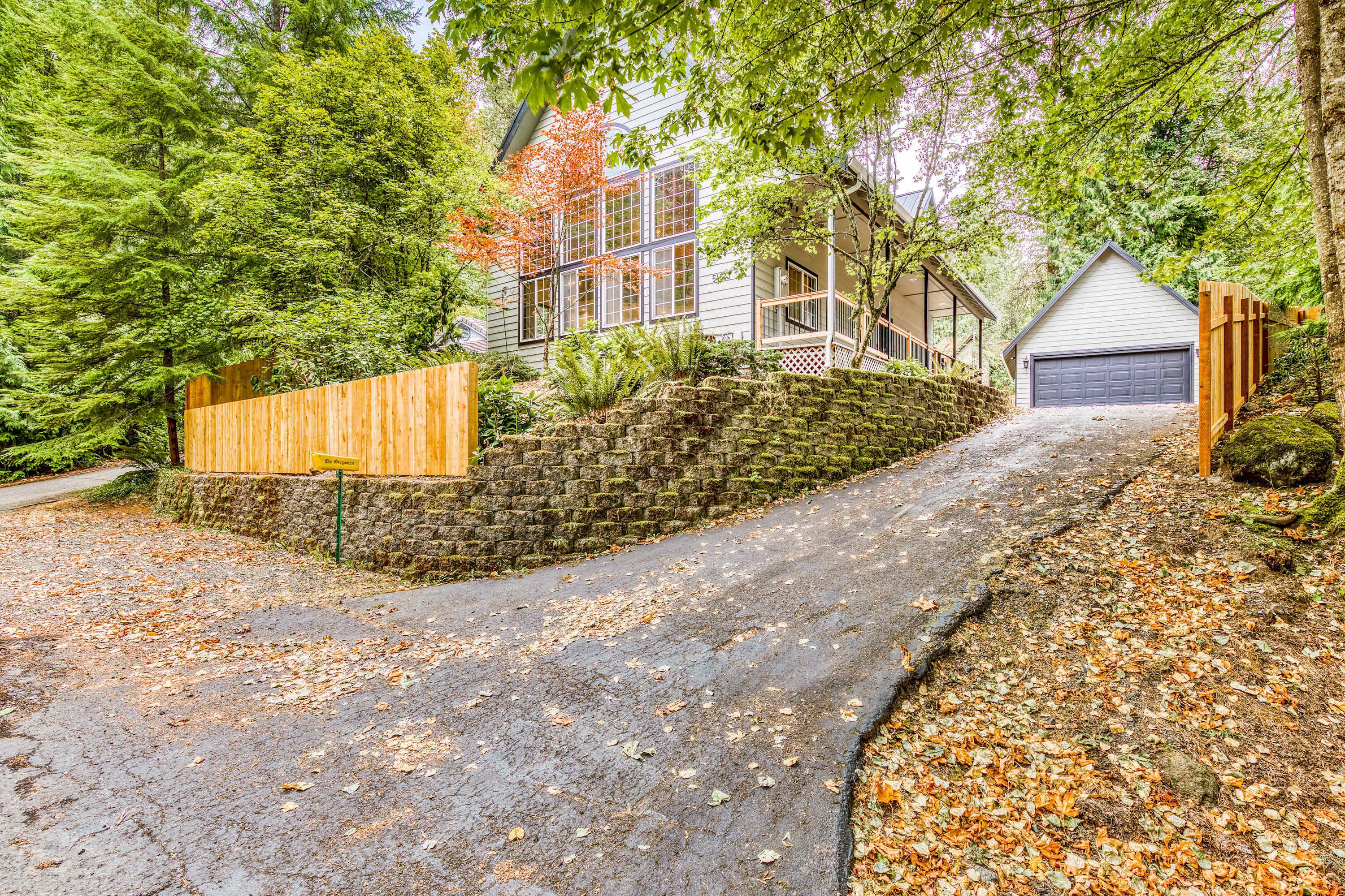 A house with a stone wall, wooden fence, and a garage.