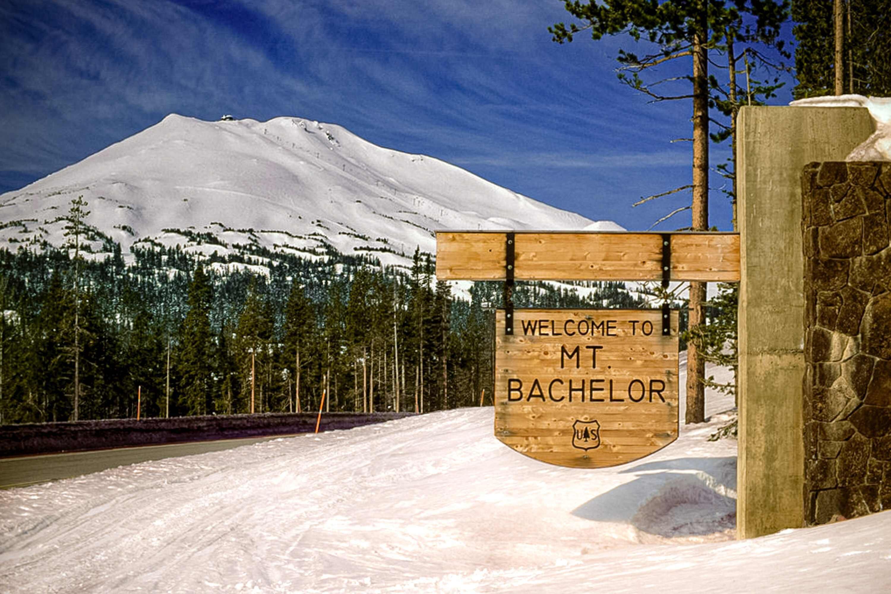 Een houten bord met 'WELCOME TO MT. BACHELOR' en een logo van de U.S. Forest Service.