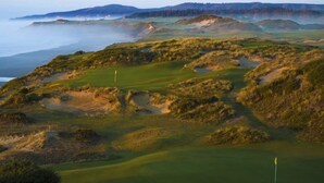 Ein Golfplatz mit Bunkern und einer Fahne.