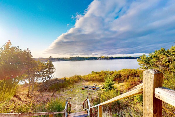 A wooden staircase leading to a lakeside area with a view of the water and distant trees. - Upstairs Apartment with River Views, Free WiFi, AC, & Beach Nearby (Florence)