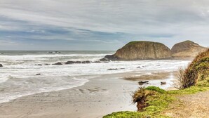Un paisaje costero con afloramientos rocosos y una playa de arena.