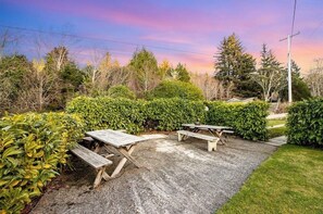 Un espace de pique-nique avec des bancs et un sentier de gravier.