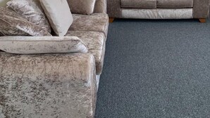 Ein Wohnzimmer mit zwei Sofas, einer Lampe und Wandbildern.