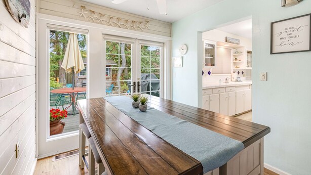 Una cucina con un piano di lavoro in legno, una ventola a soffitto e vista sul giardino.