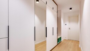 A hallway with white walls, wooden flooring, and a door at the end. - D52 Apartment Hotel (Budapest)