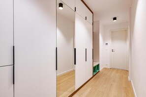 A hallway with white walls, wooden flooring, and a door at the end. - D52 Apartment Hotel (Budapest)
