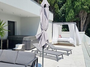 A modern outdoor lounge area with a hot tub, a covered seating area, and a canopy. - 5-bedroom Estate With Heated Pool (Kastela)