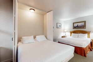 A hotel room with two beds, a wooden headboard, a nightstand with a lamp, and a framed picture on the wall. - Studio condo with access to shared pools, hot tubs, close to Mt Bachelor (Bend)