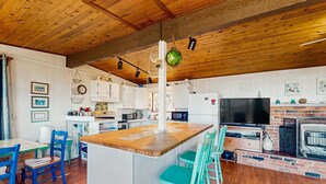 A kitchen with wooden cabinets, a central island, and a brick fireplace.