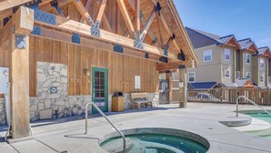 A building with a wooden exterior, a stone wall, and a pool area. - Riverfront mountain townhouse with pool & hot tub, patio, & easy ski access (Government Camp)