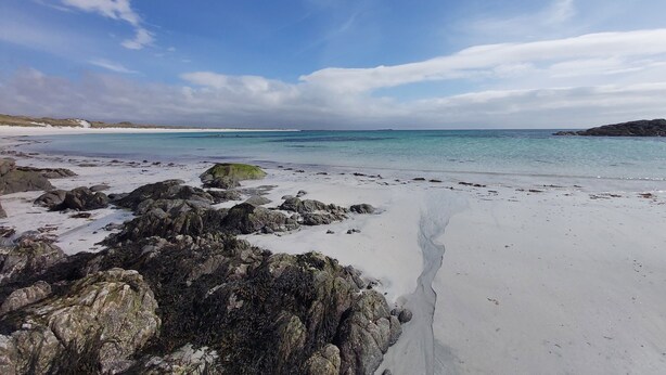 A beach with clear water, rocky foreground, and distant shoreline. - Charming Stone Cottage with Beautiful Gardens in the Heart of North Uist (HM2X+WH Isle of North Uist, United Kingdom)