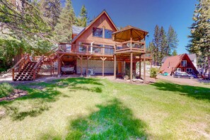 A two-story wooden cabin with a balcony, a covered porch, and a garage. - Lakefront, dog-friendly home in Joseph with amazing yard, deck (Joseph)