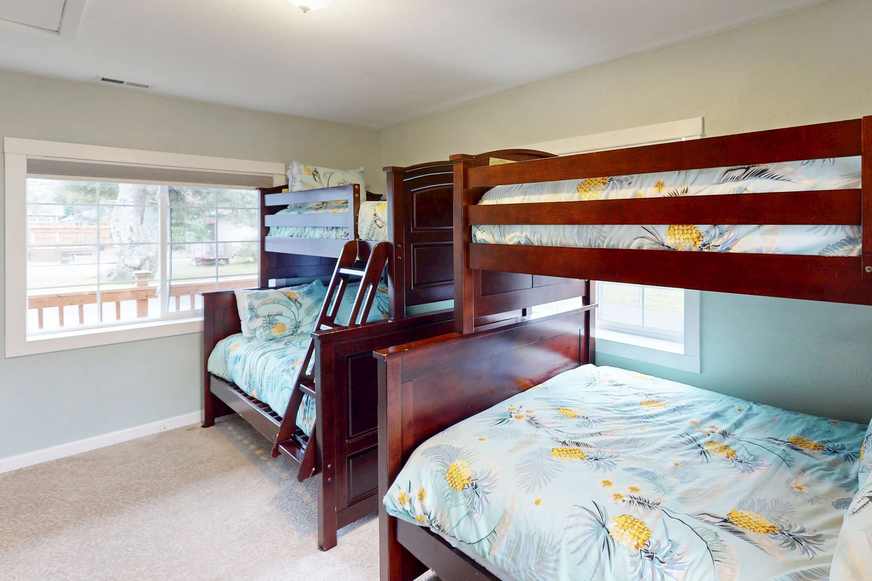A bedroom with two bunk beds, a window with a view, and a door.