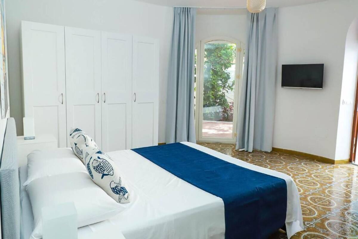 Habitación de hotel con cama, armario, televisión y vistas al exterior.