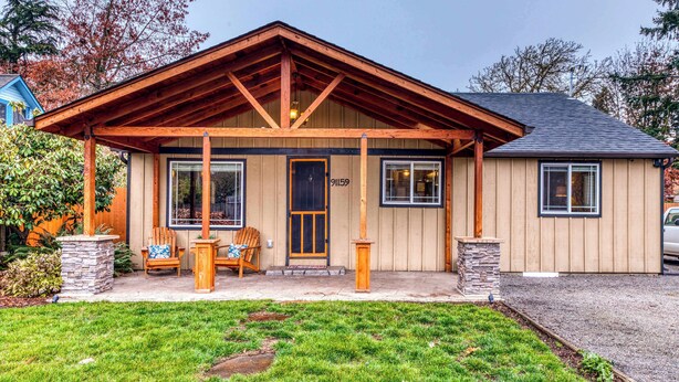 Ein Bungalow mit Veranda, einem Säule und einem Briefkasten.