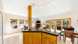 Una cocina amplia con armarios de madera, una isla central y ventanas grandes.