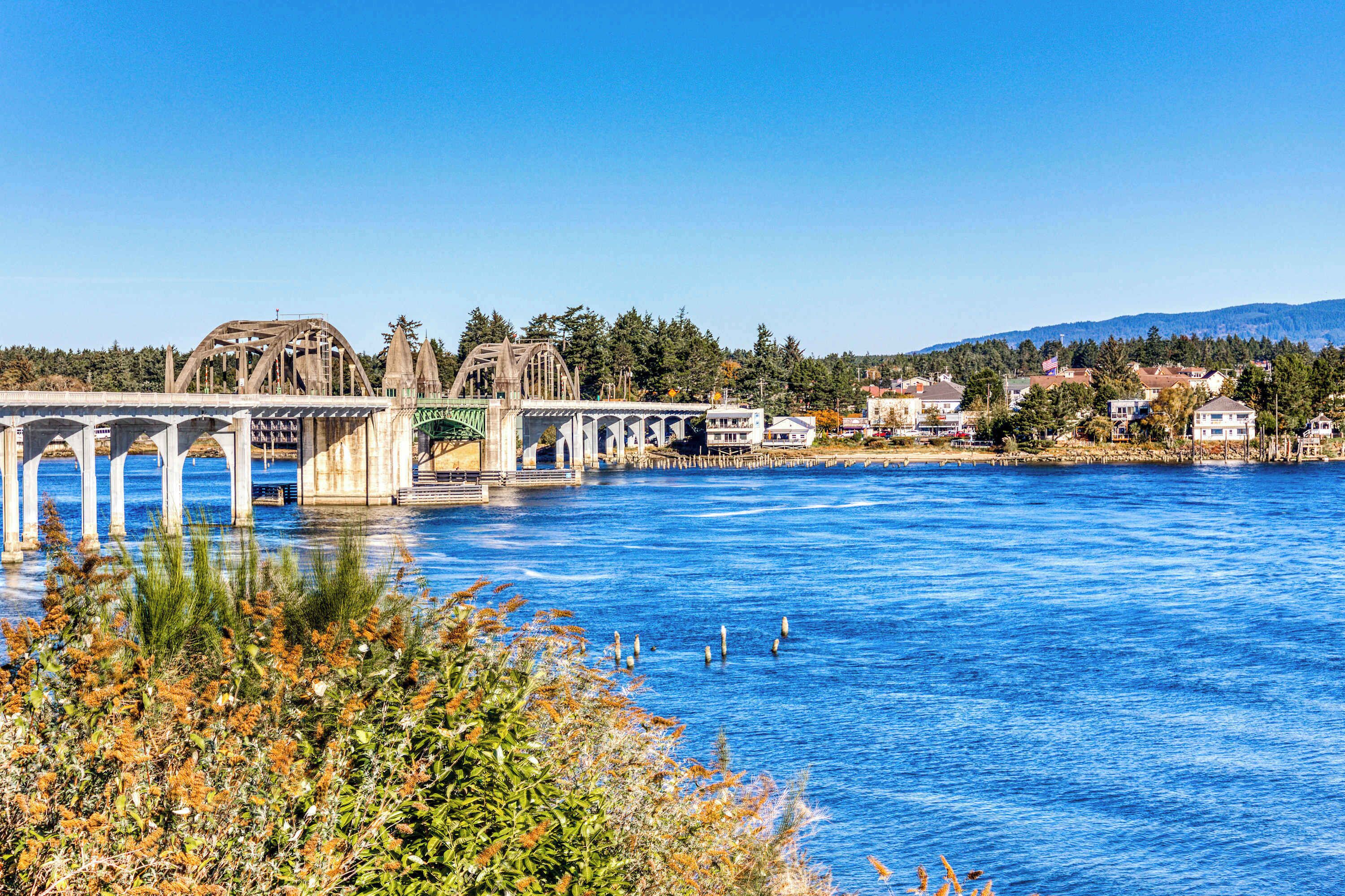 Un pont enjambant une rivière, avec une ville en arrière-plan.