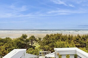 Vista costera con playa, océano y abundante vegetación.