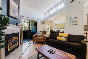 A living room with a fireplace, a sofa, a coffee table, and a TV.