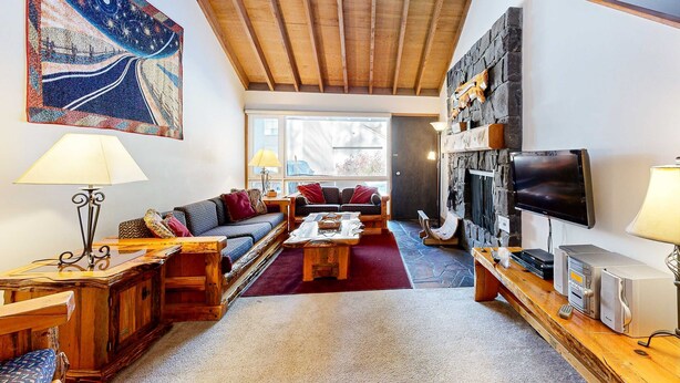 Ein gemütliches Wohnzimmer mit Sofa, Couchtisch und Kamin.