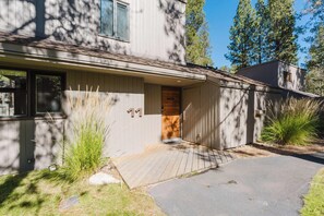 Ein zweistöckiges Haus mit einer Holzterrasse und einer Garage.