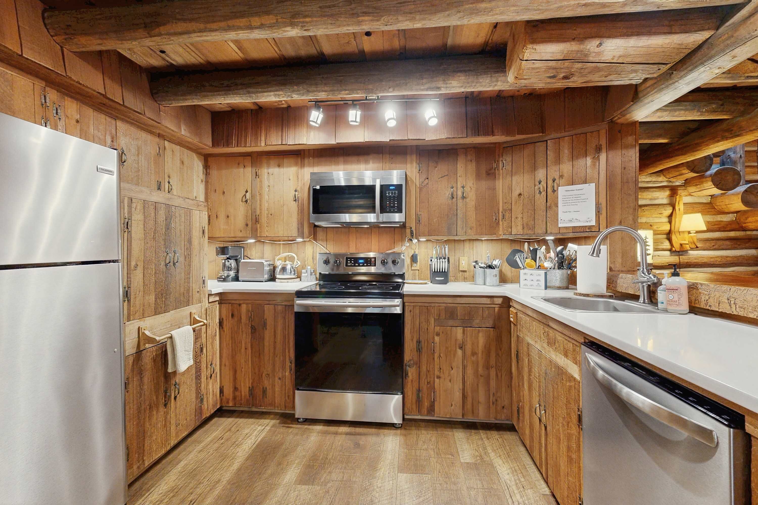 Eine Holz-Küche mit Edelstahlgeräten, einer Mikrowelle, einem Backofen und einem Geschirrspüler.