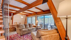 A cozy interior with a wooden ceiling, a sofa set, a patterned rug, and a dining area with chairs and a table. - Cozy Family Cabin with Hot Tub, Bikes, Dog-Friendly, Free WIFI with SHARC passes (Sunriver)