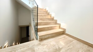 Eine moderne Treppe mit Glastrennwand und Holzboden.