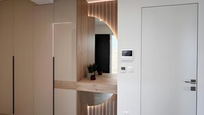 Ein modernes Interieur mit Küchenzeile, Einbaukästen, einer Holzarbeitsplatte und einer Tür mit Bedienfeld.