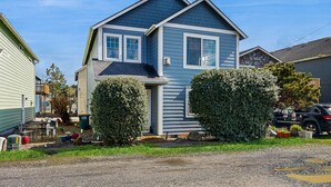 Een twee verdiepingen tellend huis met een veranda, een garage en een oprit.