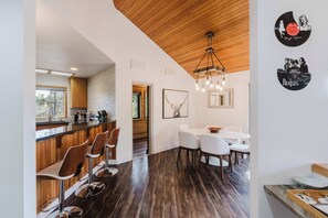 A modern kitchen with wooden cabinets and a bar area. - Multi-level home with private hot tub, decks, and SHARC passes provided (Sunriver)