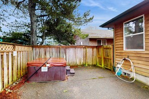Ein Garten mit Holzpforte, einem Whirlpool und einem Gartenschlauch.