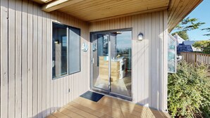 Ein Holzfassade mit einer Schiebetür, die zu einem Küchenbereich führt.
