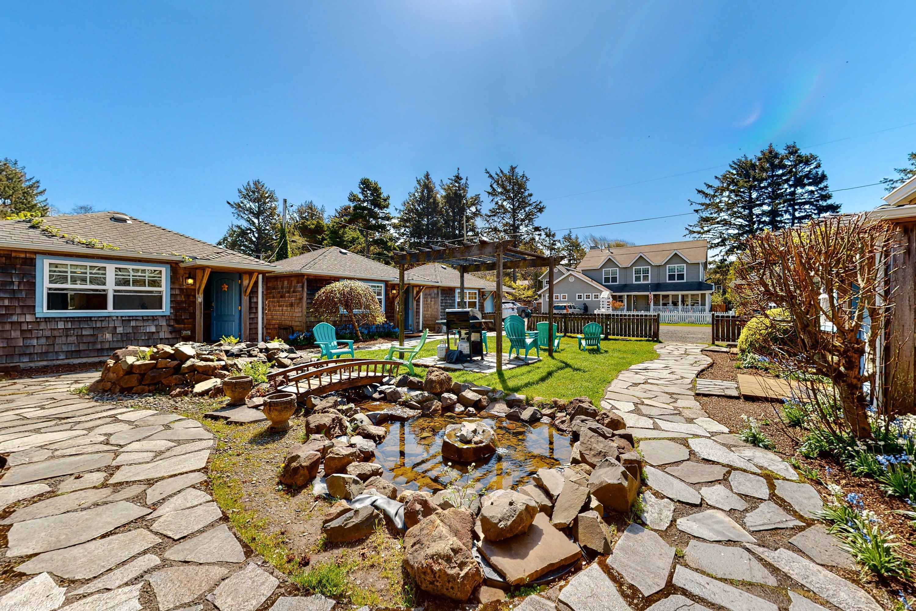 A stone patio with a pond, outdoor furniture, and a pergola.