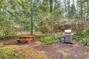 Outdoor dining - Historic riverfront Steiner cabin in forest with firepit, deck, & patio lounging (Brightwood)